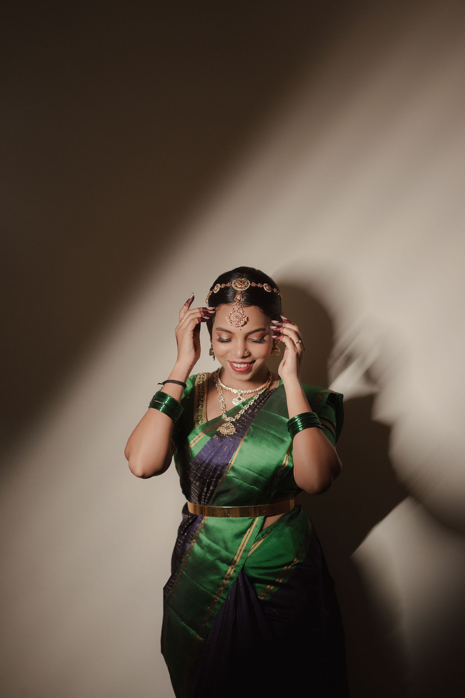 Valarmathy, photographed against a lit wall on her wedding day — Your Perfect Story